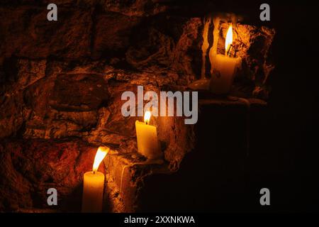 Candles on red brick wall of old castle. Stock Photo