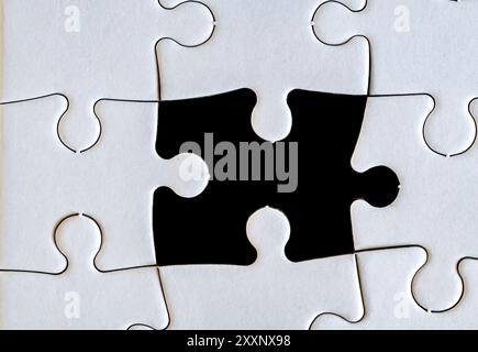 A jigsaw puzzle where a single piece is missing to complete it. Stock Photo