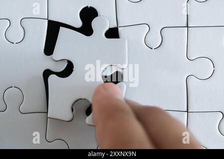 Someone placing the last piece of a jigsaw puzzle Stock Photo