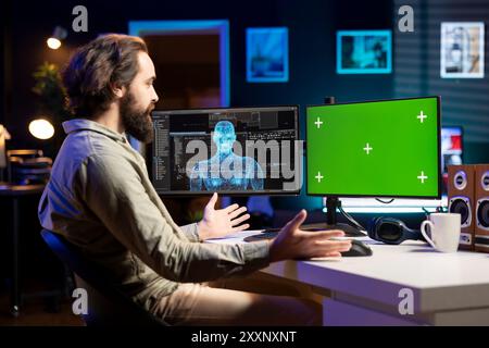 Software developer unable to believe eyes after seeing AI gaining humanoid form on green screen monitor. Computer scientist surprised by artificial intelligence materializing on chroma key display Stock Photo