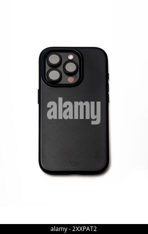 Black iPhone 15 Pro Titanium on a white background, in a case, and with aftermarket camera lens protectors. Stock Photo