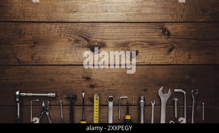Flat lay with various work tools on wooden background working table. Top view on new hand tool set for repair, construction kit, overhead. Must-have f Stock Photo