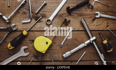 Flat lay with DYI composition of various work, carpentry tools knolled on brown wooden decks background pattern working table. Top view on new hand to Stock Photo