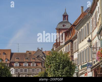 Historic old town with half-timbered houses and a church tower on a sunny day, Weissenburg, Alsace, France, Europe Stock Photo