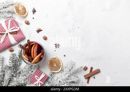 Christmas flat lay top view on white gray concrete background table with Mulled Wine glass cup or mug, present red gift boxes, decorations, cinnamon, Stock Photo