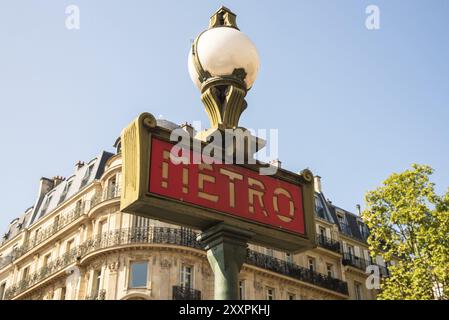 Paris, France. August 2022. Traditional Paris metro sign with buildings in the background Stock Photo