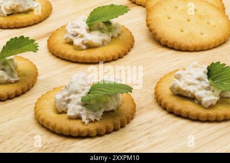 Biscuit crackers with tuna salad on wooden board Stock Photo