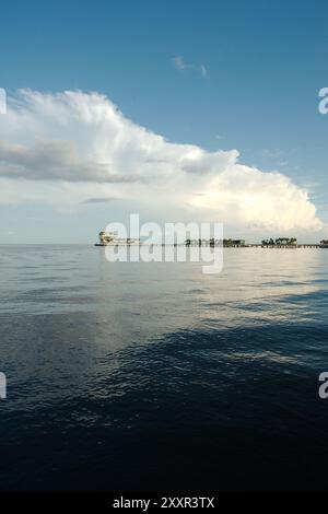 Vertical shot looking  south over calm blue water from beach St. Petersburg, FL. towards Tampa Bay and Pier in back. Partly sunny day with blue sky Stock Photo