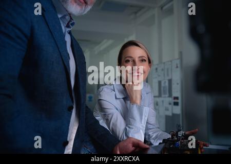 Two robotics engineers working on new project, standing in laboratory. Concept of modern technology in industries, automated processes, automotive Stock Photo