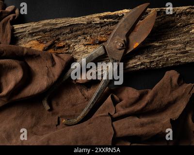 Old rusty tailors scissors on aged wood with brown fabric Stock Photo