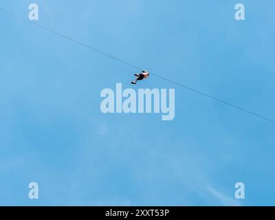 Clecy, Normandy, France, May 10, 2024. Rappelling down the mountain extreme sports, one person in a helmet. Photo from below. Cleacy in Normandy, blue Stock Photo