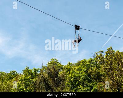 Clecy, Normandy, France, May 10, 2024. Rappelling down the mountain extreme sports, one person in a helmet. Photo from below. Cleacy in Normandy, blue Stock Photo