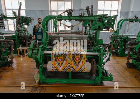 A woman is standing in front of a green machine Stock Photo