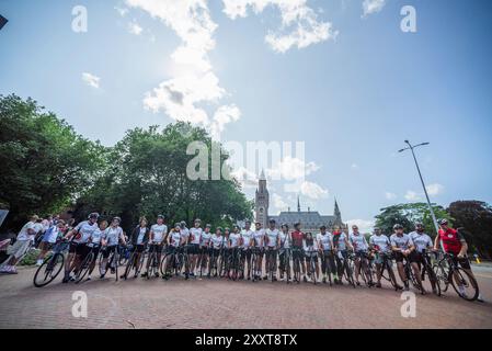 Group photo on the Carnegieplein, with the International Court of Justice (ICJ in the background, during the 2024 Cycling4Justice Campaign. Cycling4Justice Campaign in The Hague. Cycling4Gaza, in collaboration with Ajyal Foundation for Education, launched the 2024 Cycling4Justice Campaign. 100 cyclists from 28 countries participated in this year's event, almost all having flown in from the Middle East to Europe, with one member arriving from Pakistan. This year's event was dedicated to raising awareness of the 17-year blockade and the ongoing genocide in Gaza. The campaign raised more than €60 Stock Photo