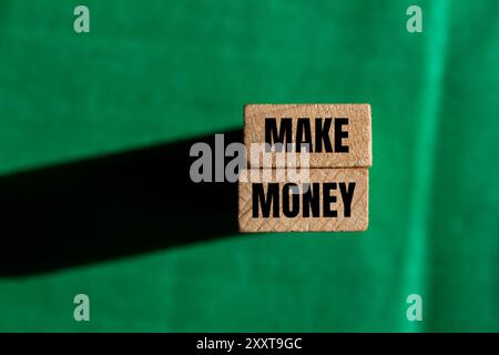 Make money message written on wooden blocks with green background Stock Photo