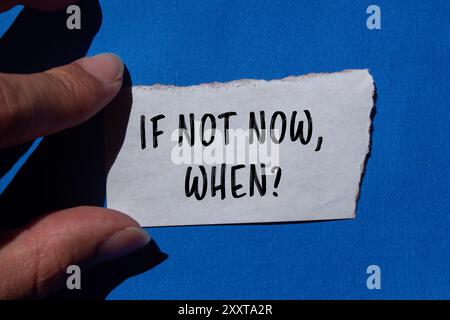If not now, when question message written on ripped torn paper piece with blue background. Conceptual if not now when symbol. Copy space. Stock Photo