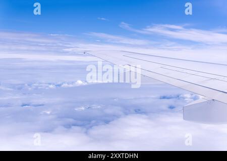 view from airplane window during flight, wing and cloudscape, view above clouds Stock Photo