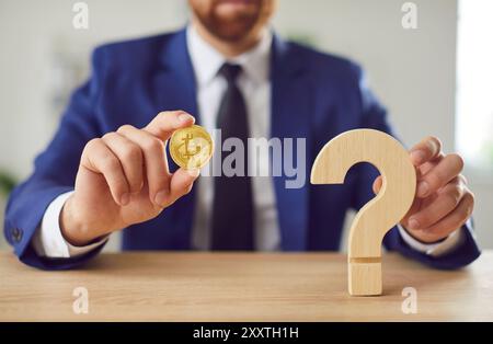 Man Holding Bitcoin Coin And Question Mark Stock Photo