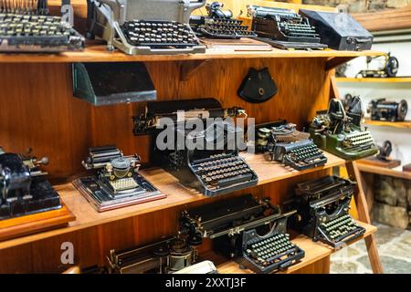 Vintage items, very old typewriters displayed on shelves. Stock Photo