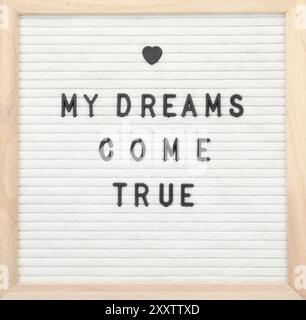 Letter board with phrase My dreams come true on white background, top view Stock Photo