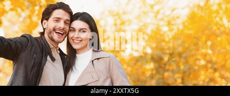 Close up of happy couple taking selfie in autumn forest Stock Photo