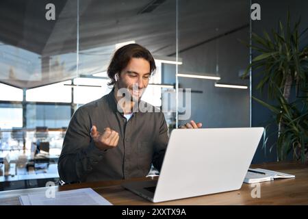 Happy business man in earbuds working using laptop communicating on video call. Stock Photo