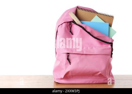 Backpack with notebooks and ruler on wooden table against white background, space for text Stock Photo