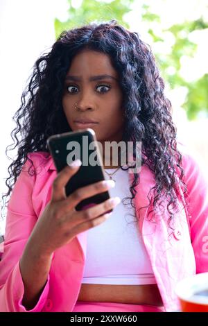 Young happy African American woman browsing the Internet with smart mobile application  Stock Photo