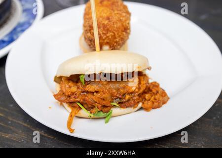 A plate of delicious tapas showing a Chicken tikka masala in a bao bread Stock Photo