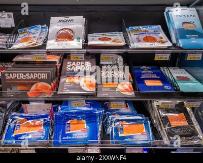 Italy - July 30, 2024: Smoked salmon of Norwegian and Scottish origin sliced in packs of various brands displayed in refrigerator Italian supermarket Stock Photo