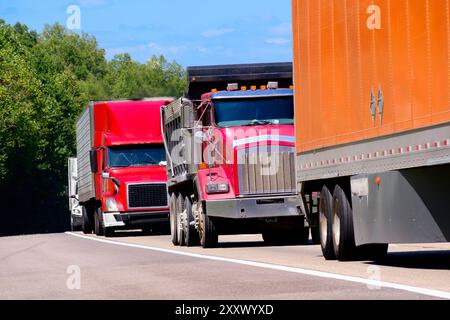 Horizontal shot of a color convoy of heavy semi trucks on the highway ...