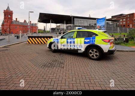 South Wales police car - Heddlu - outside the Welsh Parliament Building - Senedd Cymru and sign for Assembly Square, Cardiff Bay. Taken 2024 Stock Photo