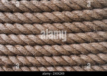 A full frame background of thick shipping rope tightly wrapped together and made from durable natural fibres such as Jute with copy space Stock Photo