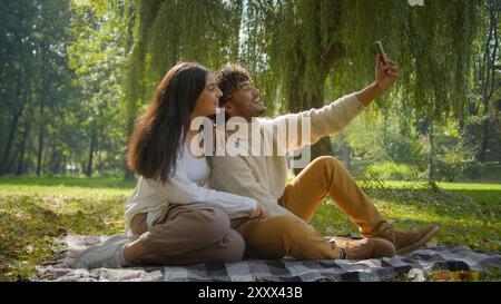 Happy multiracial couple Hispanic girlfriend woman Indian man boyfriend smile wave hello talking video call stream mobile phone partners family male Stock Photo