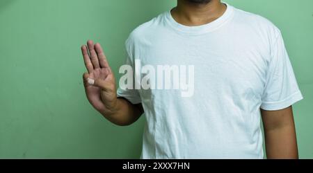 young man keeping hand raised and forming letter W on sign language Stock Photo