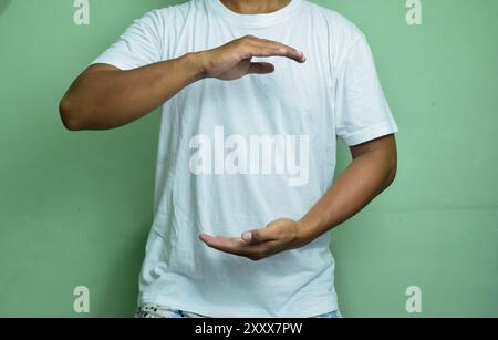 man holding hands near chest on green background Stock Photo