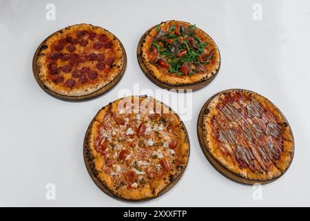 Pizza set with meat and cheese. Pepperoni pizza with arugula and prosciutto. Meat pizza with cheese, cherry tomatoes and hot jalapeno pepper on a whit Stock Photo