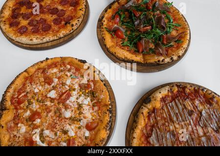 Pizza set with meat and cheese. Pepperoni pizza with arugula and prosciutto. Meat pizza with cheese, cherry tomatoes and hot jalapeno pepper on a whit Stock Photo