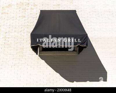 Black canvas window awning on white brick wall. Stock Photo