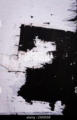 Wall with torn black and white and pealing paper. Stock Photo