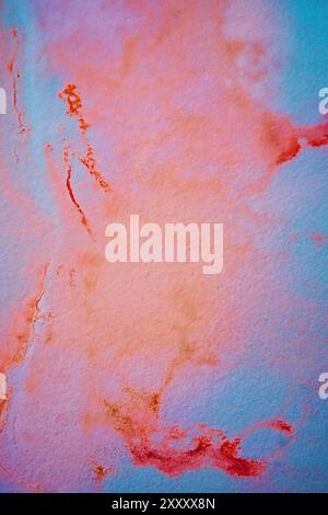 Wall with psychedelic watercolor stains in shades of blue, red, orange, and purple. Stock Photo
