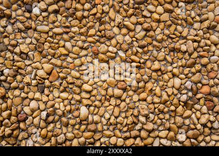 Decorative wall with beige and brown pebbles and stones Stock Photo