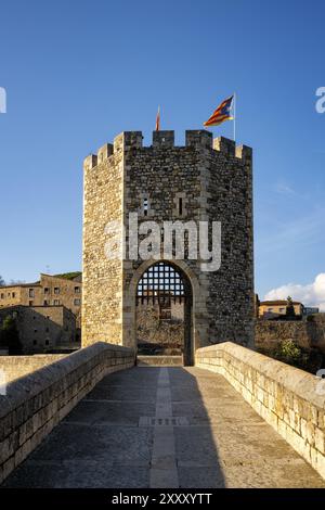 Besalu historic medieval city with Catalonia flags on the stone bridge tower crossing El Fluvia river, in Spain Stock Photo