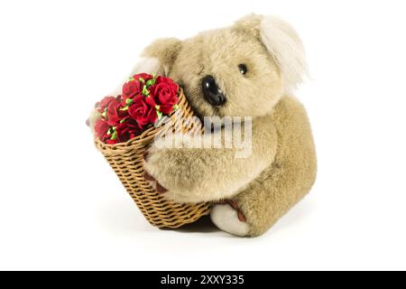 Teddy bear carrying bamboo basket full of red roses on white background Stock Photo