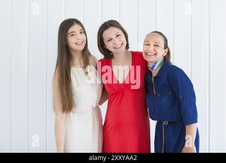 Happy female friends with pregnant woman on white background Stock Photo