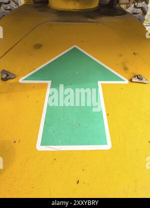 Green arrow pointing upwards on a machine Stock Photo