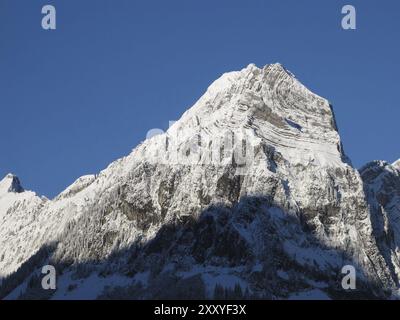 Snow Capped Mountain Peak With Visible Rock Layers Stock Photo