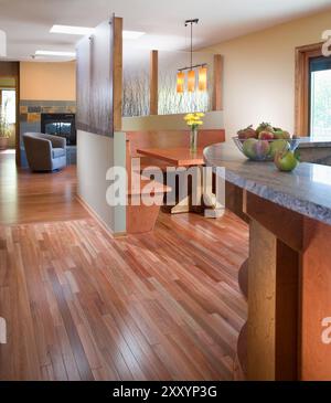 View from kitchen showing part of counter and built in seating area with fireplace and sitting area in background Stock Photo