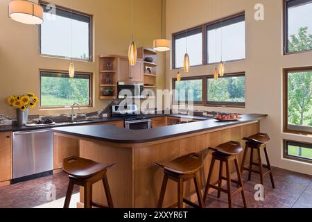 Warm, sunny kitchen with lots of large windows in passive solar house Stock Photo