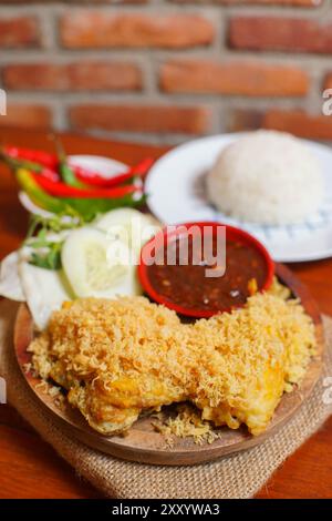 indonesian food on the table. Crispy fried chicken served with shrimp paste chili sauce and fresh vegetables and warm rice. Stock Photo